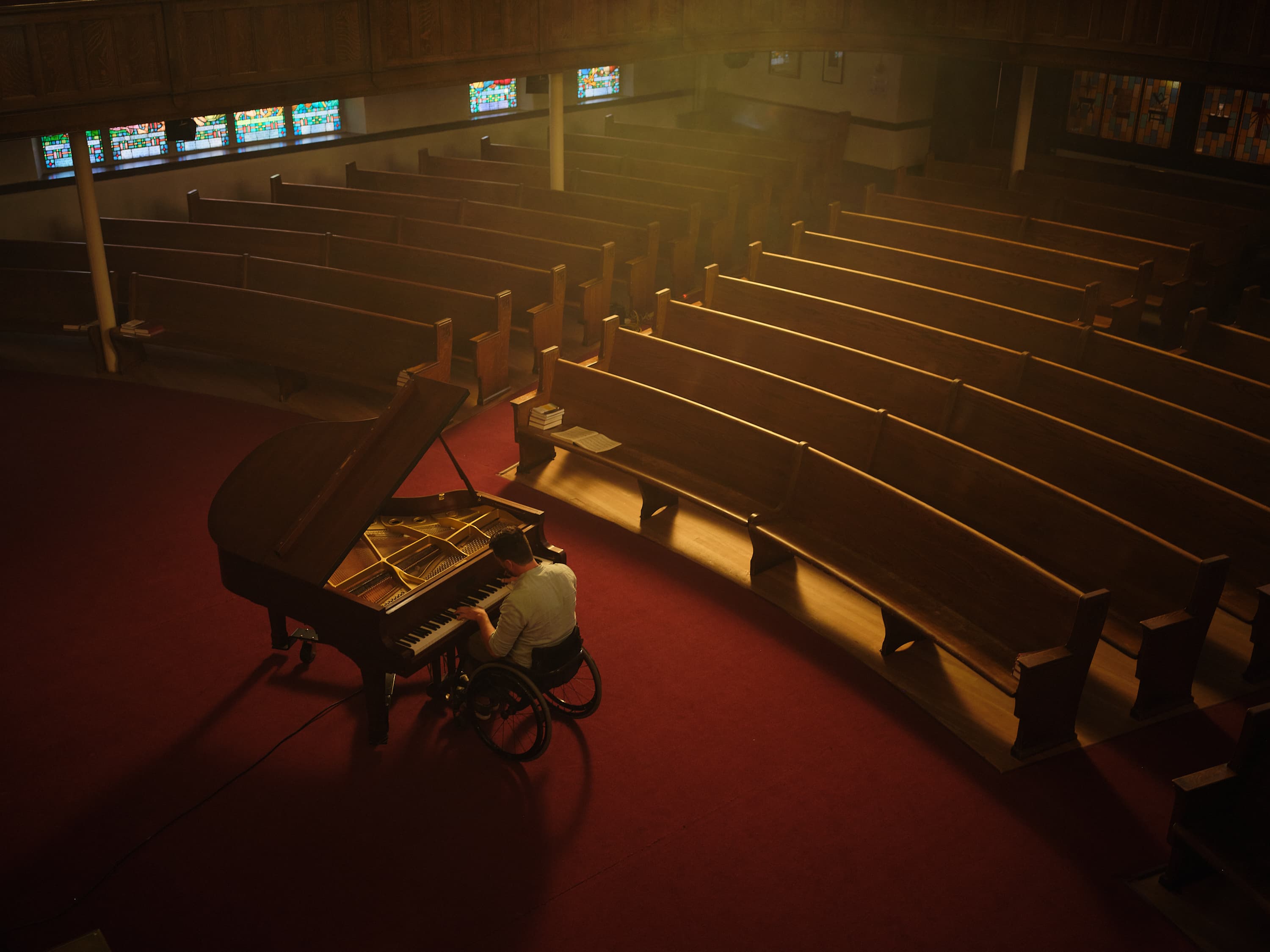 Riccardo playing the piano in a wheelchair